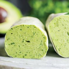 an avocado wrap is cut in half on a marble platter