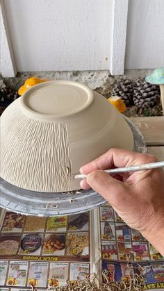 a person is making a vase out of clay