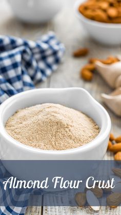 almond flour in a white bowl with the words almond flour on it and nuts scattered around