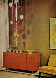 a living room scene with focus on the sideboard and hanging ornaments in the corner