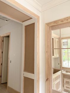 an empty room with unfinished walls and wood trim around the window panes that have been framed in