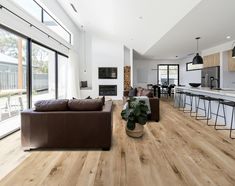 a living room filled with furniture next to a kitchen and an open concept dining area