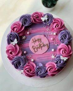 a birthday cake decorated with pink and purple icing