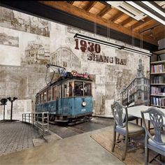 an old trolley car is parked in front of a wall mural