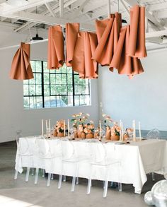 a table is set up with candles and vases for an orange themed wedding reception