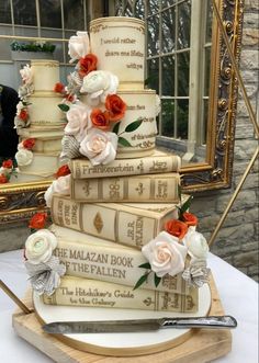 a wedding cake made out of books and flowers