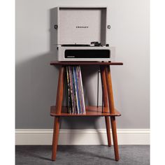 an old fashioned record player sitting on top of a wooden stand