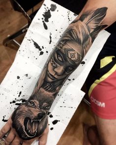 a man's arm with an owl and wolf tattoo on the left side of his arm