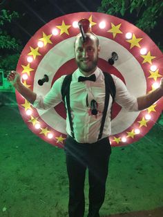 a man standing in front of a large sign with lights on it's face