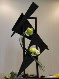 a black sculpture with flowers on top of it