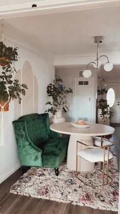 a living room filled with furniture and a white table surrounded by potted plants on top of a rug