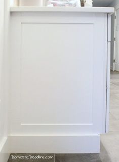 a kitchen with white cabinets and tile flooring