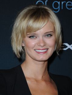 a woman with blonde hair smiling at the camera