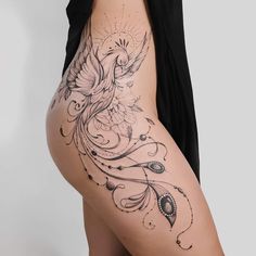 a woman's thigh with a bird tattoo on the side and an intricate design