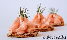 three pieces of bread topped with shrimp and dill sprinkled on top of each other