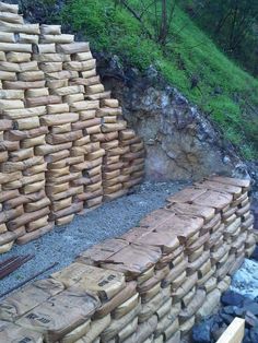 a pile of wood sitting on top of a lush green hillside