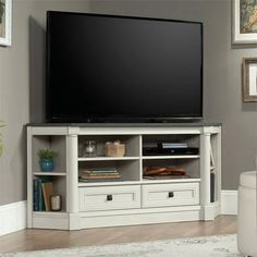 a flat screen tv sitting on top of a white entertainment center in a living room