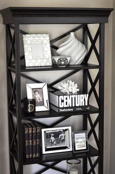 a black book shelf with pictures and other items on it