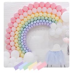 a rainbow balloon arch with pastel colors and balloons