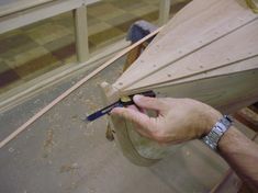 a person cutting wood with a pair of scissors