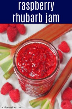 raspberry rhubarb jam in a jar surrounded by fresh raspberries