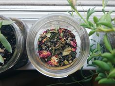 two glass jars filled with different types of flowers next to each other on a window sill