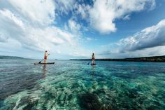 two people are paddle boarding in the ocean