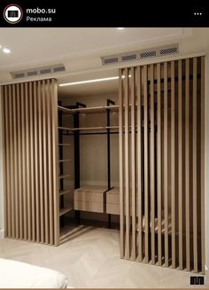 an open closet with wooden slats on the doors and shelves in front of it