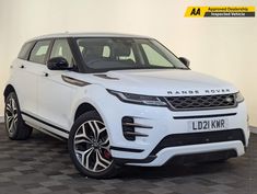 a white range rover is parked in a room with black and gray checkered flooring