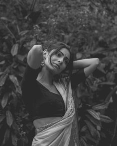 black and white photo of woman in sari posing for the camera with her arms behind her head