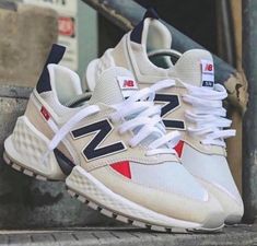 a pair of new balance shoes sitting on the steps