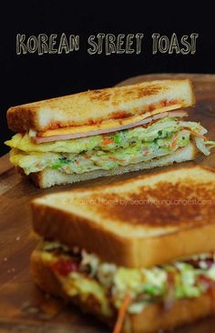 two grilled sandwiches sitting on top of a wooden cutting board next to each other