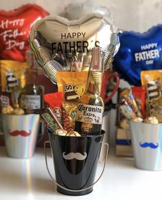 a father's day gift in a bucket filled with chocolates, candy and balloons