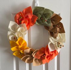 a wreath made out of fabric flowers on a door