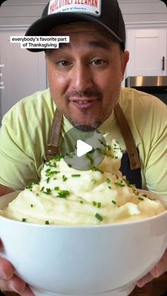 a man holding a white bowl filled with mashed potatoes