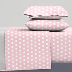 pink and white polka dot bedding with matching pillowcases on top of each other