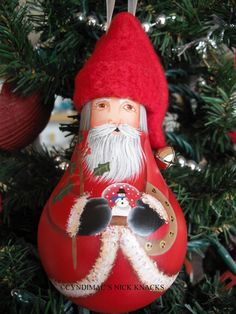 a christmas ornament with a santa clause on it's face hanging from a tree