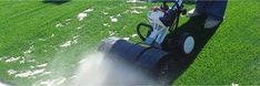 a man is using a lawn mower to cut grass in the middle of a field