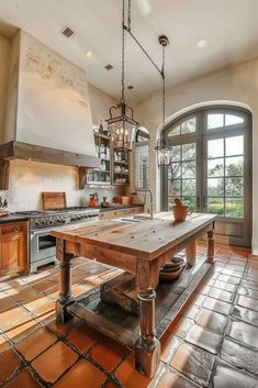 a large kitchen with an island in the middle and lots of windows on both sides