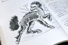 an open book with chinese writing on the pages and a drawing of a dragon riding a horse