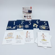 the birth of jesus cards are displayed on a white surface with blue and gold trimmings