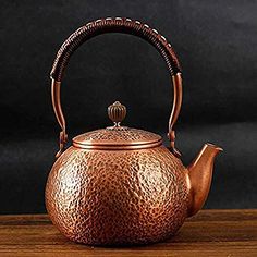 a tea pot with a handle on top of a wooden table