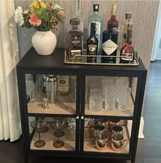 a bar cart with liquor bottles and glasses on it