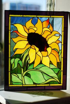 a stained glass sunflower sitting on top of a table