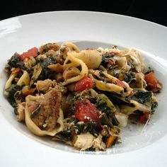 a white plate topped with pasta and vegetables