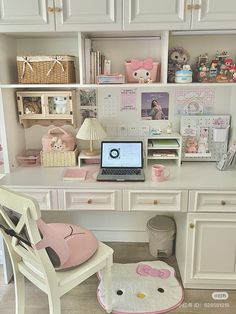 a white desk topped with a laptop computer next to a pink kitty rug and chair