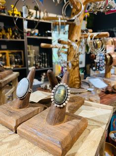 two wooden rings sitting on top of each other in front of a display case filled with jewelry