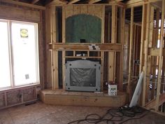 an unfinished living room with wood framing and a tv in the corner on the wall