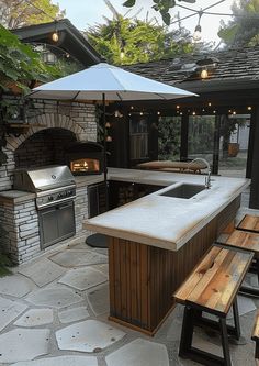 an outdoor kitchen with grill and picnic table