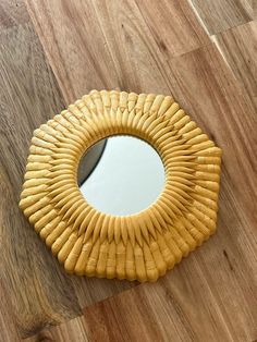 a round mirror sitting on top of a wooden floor next to a wood flooring board